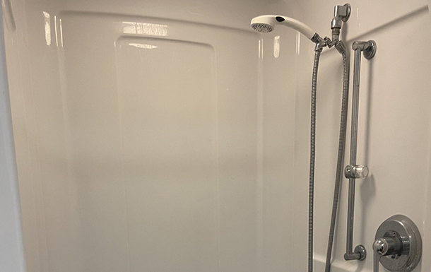 shower head and stall in the bathroom of the gemini building at camp