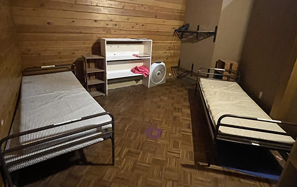 two beds and dresser in the bedroom space in the gemini building at camp