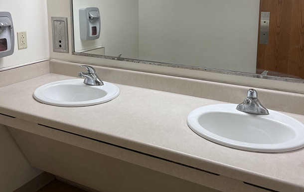 two sinks and mirror in the bathroom of the gemini building at camp