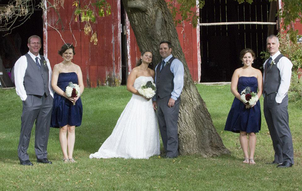wedding party poses by the barn at camp