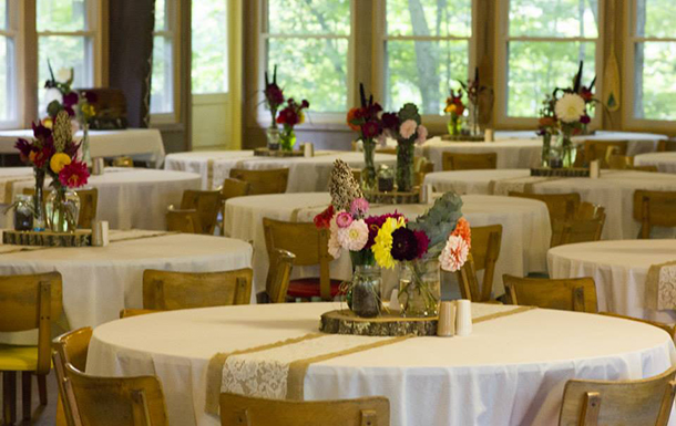 close up of floral decorations on the tables in the dining hall for a wedding reception