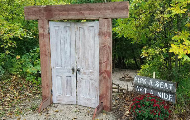 rustic door archway and wedding ceremony sign decorations at camp for a wedding ceremony