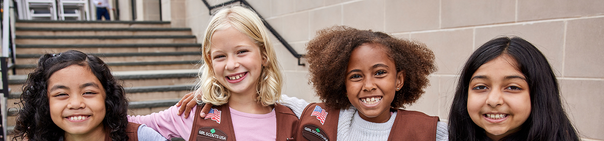  group of brownie girl scouts smile linking arms 
