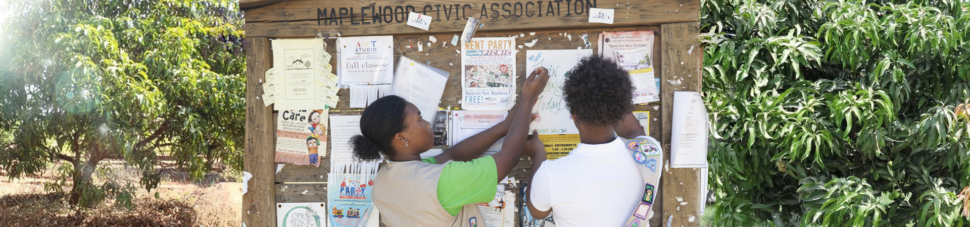  two girl scouts posting flyers on a community message board 