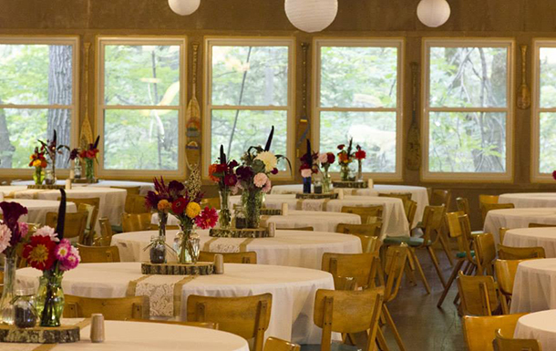 decorated tables in the dining hall for a wedding