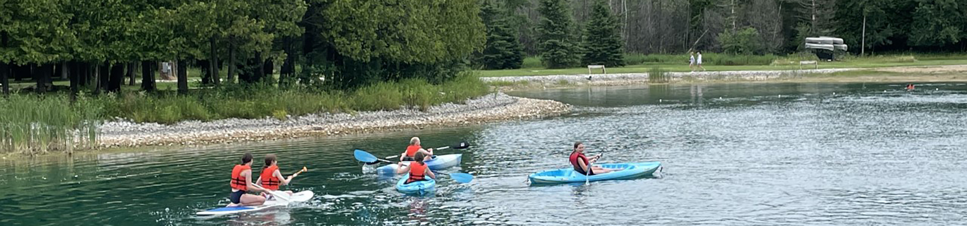  group of girls kayaking and paddle boarding on a lake 